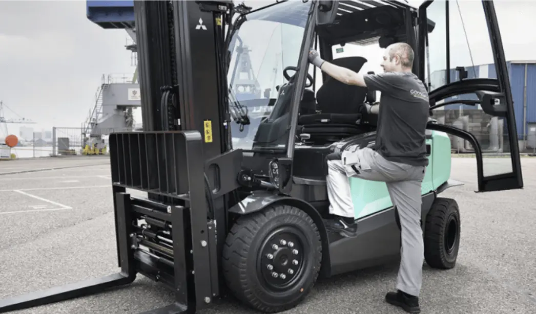 Een man klimt in een elektrische heftruck